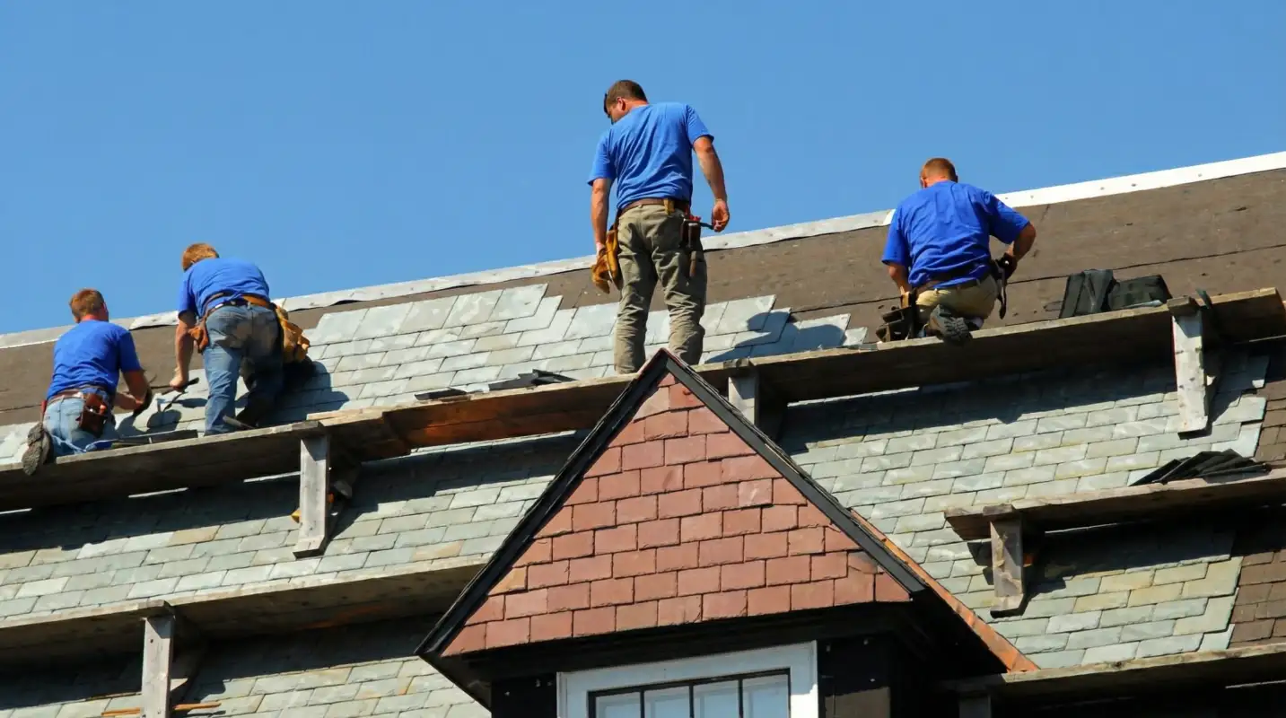 Roof replacement in progress with a team of professional contractors installing new shingles on a residential home in Fargo, ND